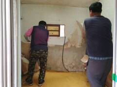 장흥군 장흥읍 복지기동대원 2명이  낡은 집 벽면의 도배와 장판을 제거하는 작업을 하고 있는 모습