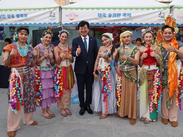 정남진 장흥 물축제, 태국 송크란 축제 현수막이 걸린 천막앞에서 축제관계자들 따봉포즈를 취하며 사진찍는 모습(크게보기)