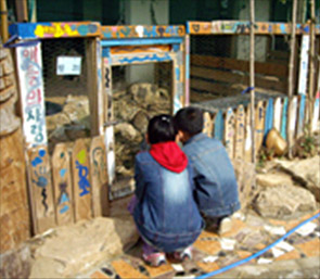 두 명의 남성이 조형물을 가까이서 보고있는 사진