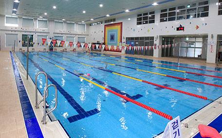 실내수영장 내부사진으로 물위에 색색의 레일가드가 서치되어있다.