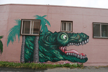 무시무시하게 생긴 초록색 공룡이 그려져 있는 벽화