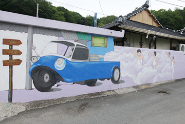하얀연기를 내뿜는 소독차를 따라가고 있는 동네 아이들 모습이 그려져 있는 벽화