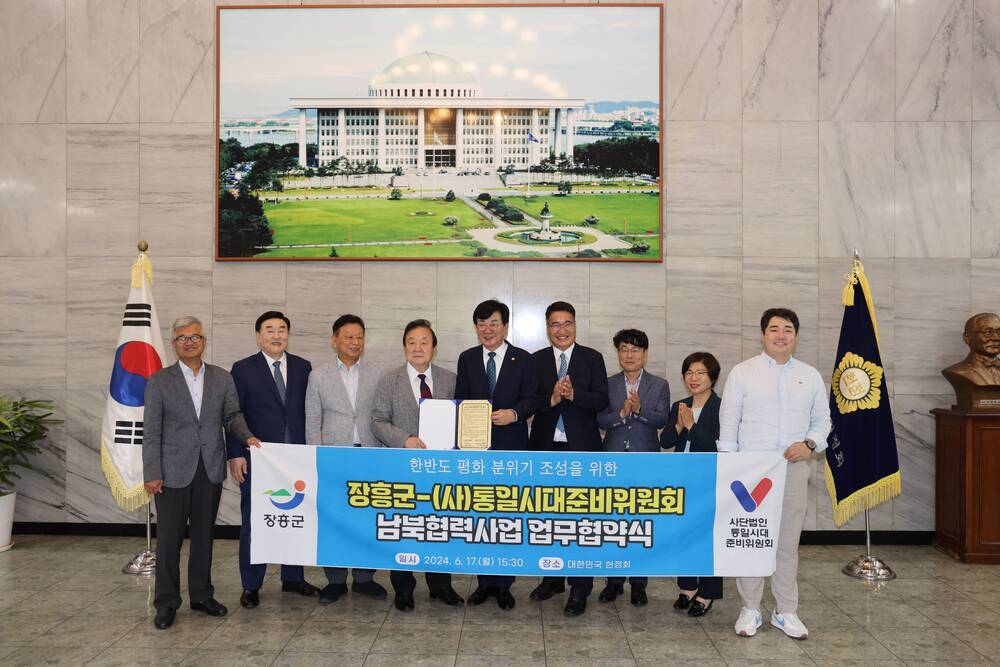 한반도 평화 분위기 조성을 위한 장흥군 -(사)통일시대준비위원회 남북협력사업 업무협약식 장흥군 사단법인 통일시대 준비위원회 현수막을들고 사진을 찍는 관계자들